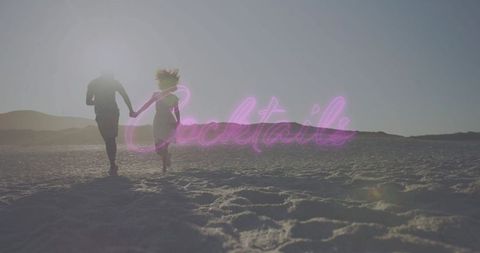 Romantic couple running on beach at sunset with neon cocktails sign, silhouetted duo