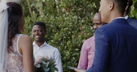 Bride and groom exchanging vows outdoors in joyful wedding ceremony