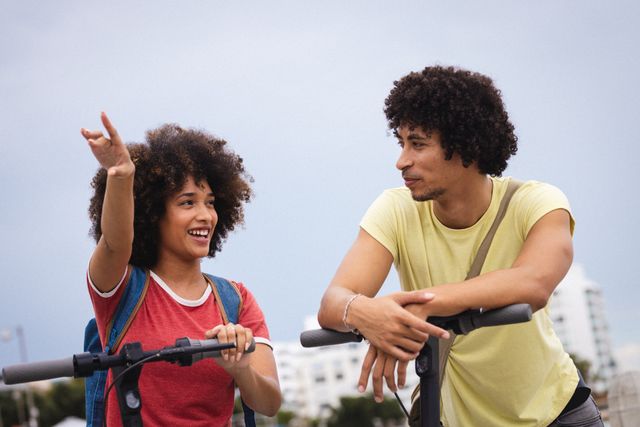 Smiling afro young woman pointing away while talking with african american boyfriend. unaltered, lifestyle, love and togetherness concept.
