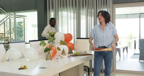 Colleagues preparing for office party decorate and arrange food