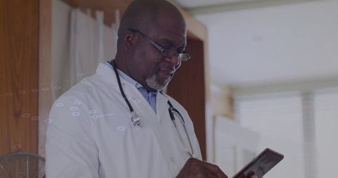 Senior doctor reviewing data on tablet in clinic