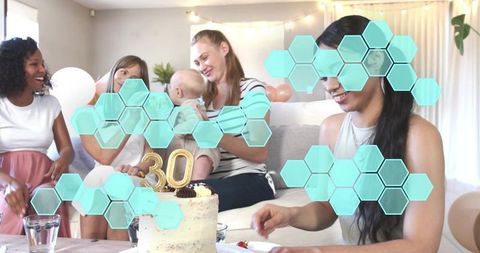 Laughing friends celebrating 30th birthday, holding baby, cutting cake at pastel party