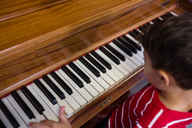 High angle view of boy playing piano in classroom at school