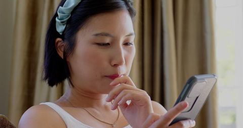 Woman Engaging with Smartphone at Home in Relaxed Atmosphere