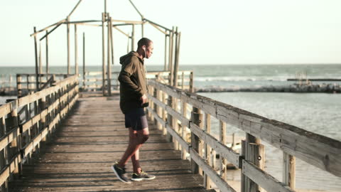 Man Exercising on Promenade Wearing Headphones