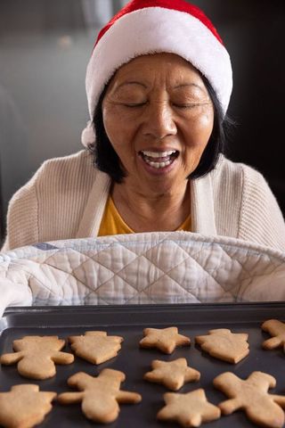 Elderly Woman Baking Holiday Cookies in Festive Santa Hat