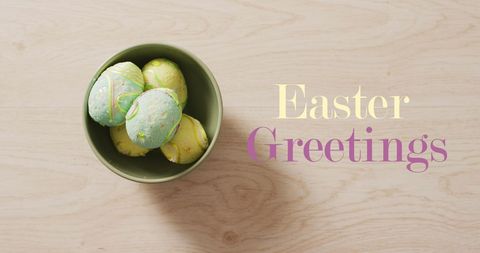 Colorful easter eggs in bowl with easter greetings text