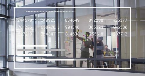 Team brainstorming on glass wall with sticky notes and digital dashboard overlay