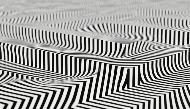 Striped chevron wave pattern creating optical 3d illusion in monochrome