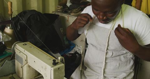 Tailor threading in small workshop, fostering craftsmanship