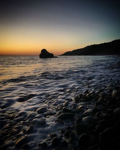 Tranquil Sunset over Rocky Beach Seascape Horizon