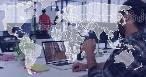 Global Remote Team Collaborating on Laptop in Open-Plan Office with World Map Network Overlay