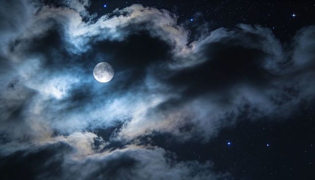Glowing Full Moon Peeking Through Layered Clouds Over Starry Night Sky Casting Silvery Moonlight