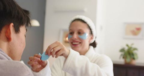 Couple applying blue hydrogel under-eye patches at home relaxing skincare ritual