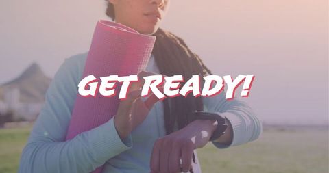 Motivated woman checking smartwatch before yoga session