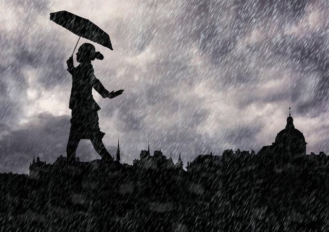 Silhouette of woman holding umbrella and walking in the rain
