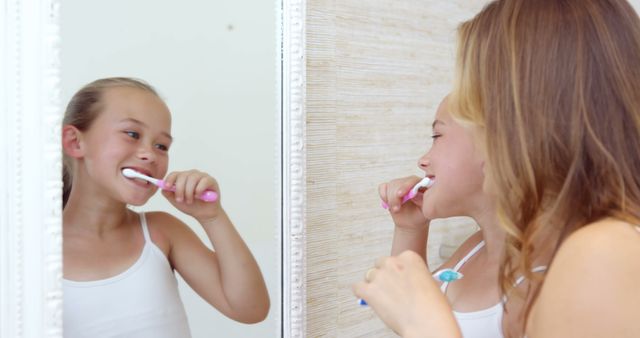 Young Girls Brushing Teeth Together in Bathroom Mirror - Download Free Stock Images Pikwizard.com