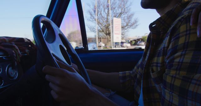 Person driving car and holding steering wheel in urban area - Download Free Stock Images Pikwizard.com