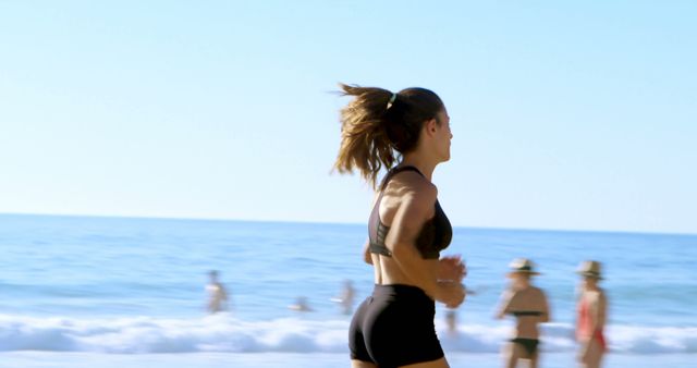 Active woman jogging on the beach, with copy space. Outdoor exercise promotes a healthy lifestyle and mental well-being.