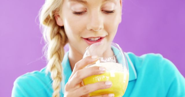 Smiling Woman Enjoying Fresh Orange Juice Against Purple Background - Download Free Stock Images Pikwizard.com