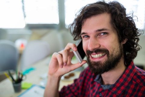 Casual Businessman Talking on Phone in Office Environment