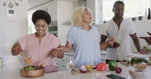 Friends Preparing Meal Together in Modern Kitchen Setting