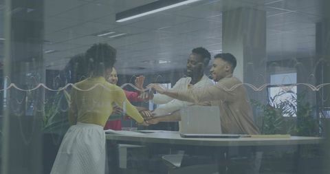 Diverse Team Joining Hands Over Standing Table in Modern Office Collaborative Huddle Unity