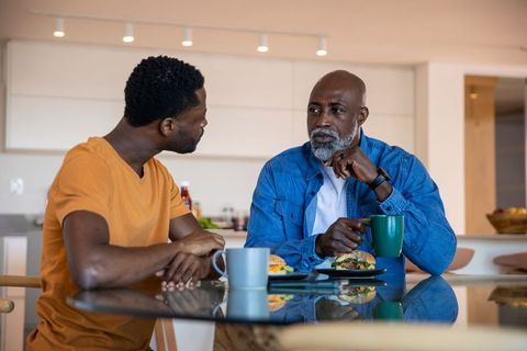 Father and Adult Son Engaging Over Breakfast in Modern Kitchen