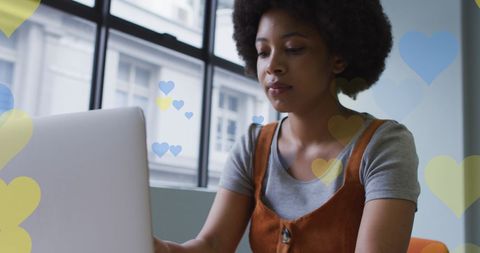 Creative Young Woman Using Laptop with Falling Heart Animation