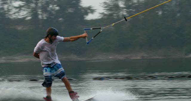 Man Wakeboarding on Lake with Forest Background - Download Free Stock Images Pikwizard.com