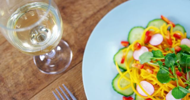 Fresh vegetable salad with glass of white wine on wooden table - Download Free Stock Images Pikwizard.com