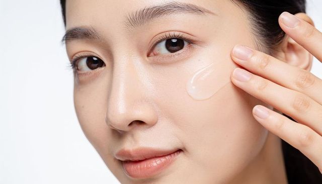 Asian woman applying translucent gel moisturizer to cheek closeup skincare hydration routine