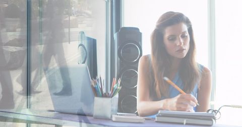 Businesswoman Working in Modern Office Overlaid with Cityscape