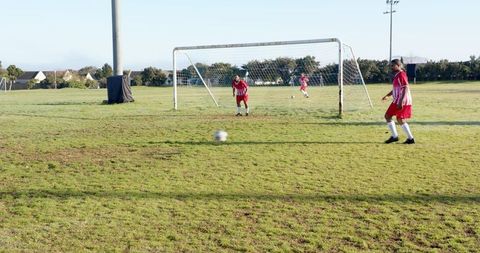 Youth soccer defense with goalkeeper and defenders on grass field