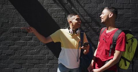 Happy Friends Traveling with Backpacks Smiling in Sunlight