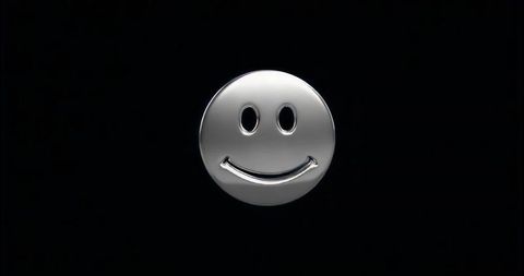 Floating chrome smiley face reflecting light on black background, minimalist futuristic