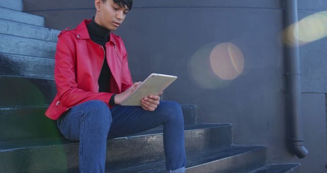 Young man sitting on urban stairs using tablet - Download Free Stock Images Pikwizard.com