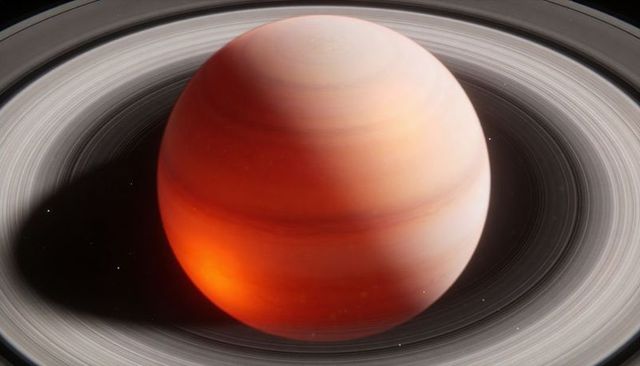Ringed gas giant casting deep shadow across concentric rings over starfield