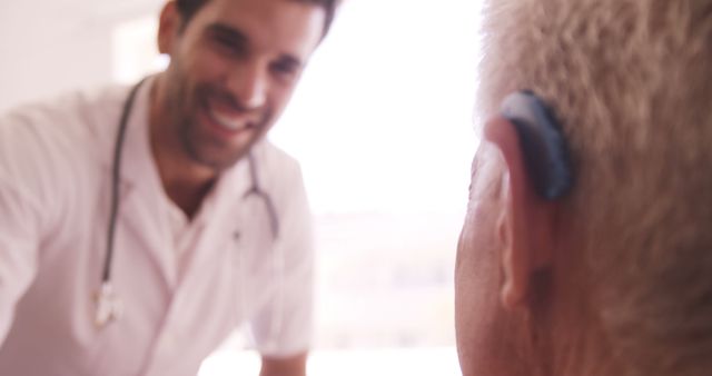 Doctor Assisting Senior Patient with Hearing Aid - Download Free Stock Images Pikwizard.com