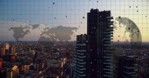Urban skyline at sunset with digital world map overlay and futuristic glass skyscrapers
