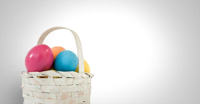 Digital composite of Easter eggs in basket in front of grey background