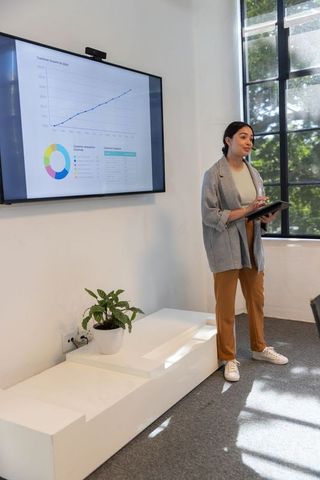Professional Woman Presenting Business Insights with Technology in Modern Office