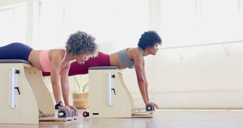 Two Women Engaging in Pilates Workout on Reformers - Download Free Stock Images Pikwizard.com