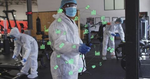Sanitation team sanitizing gym equipment in full ppe with digital health data overlay