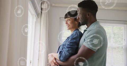 Affectionate couple embracing in sunlit modern living room