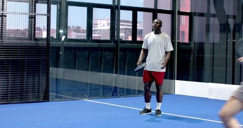 Athletic Men Competing on Vibrant Blue Padel Court