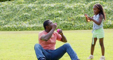 Father and daughter enjoying outdoor bubble fun