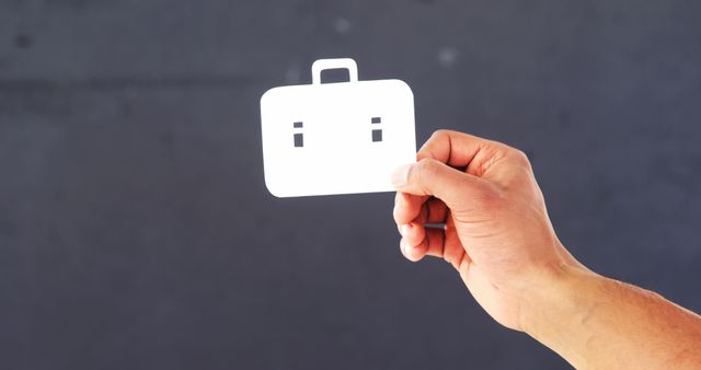 Hand Holding White Card Smiling Suitcase Icon on Dark Background - Download Free Stock Images Pikwizard.com