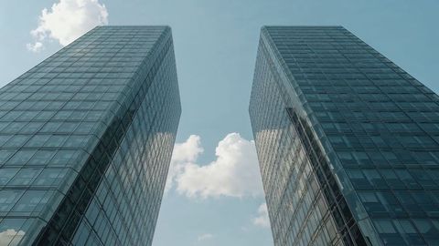 Modern Glass Skyscrapers Reflecting Clouds in Urban Panorama
