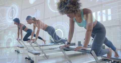 Diverse Women Exercising on Pilates Reformers with Digital Elements